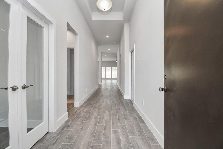 As you step into the threshold of this luxurious home, you'll soon be welcomed by an elegant glass door (to be installed). Inside, soaring ceilings amplify the spaciousness, while the refined wood-look tile flooring and oversized baseboards exude sophistication and charm. Sample photo of completed home with similar floor plan. Actual colors and selections may vary. As you step into the threshold of this luxurious home, you'll soon be welcomed by an elegant glass door (to be installed). Inside, soaring ceilings amplify the spaciousness, while the refined wood-look tile flooring and oversized baseboards exude sophistication and charm. Sample photo of completed home with similar floor plan. Actual colors and selections may vary.