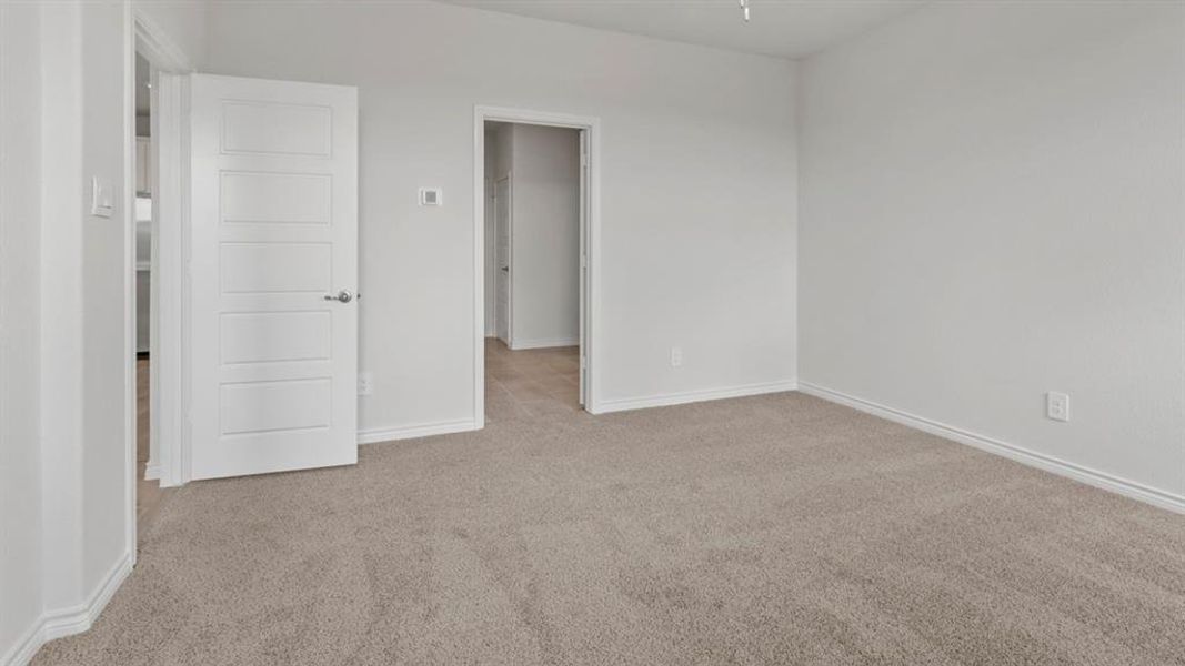Unfurnished bedroom featuring light colored carpet and baseboards