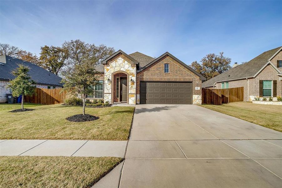 View of front facade with a garage and a front lawn