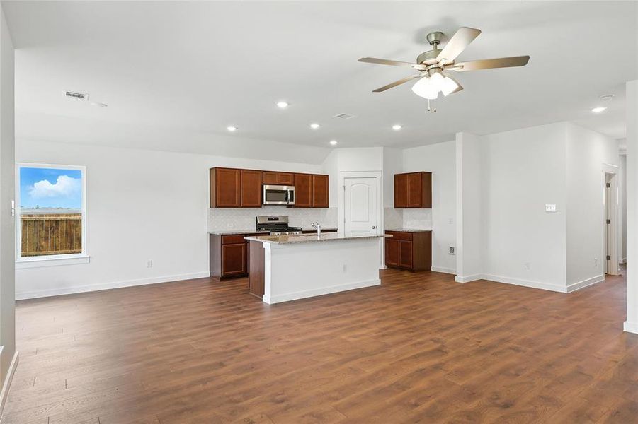 Kitchen featuring appliances with stainless steel finishes, open floor plan, recessed lighting, a ceiling fan, and backsplash Kitchen featuring appliances with stainless steel finishes, open floor plan, recessed lighting, a ceiling fan, and backsplash