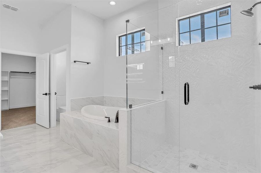 Bathroom with shower with separate bathtub, tile patterned flooring, and toilet