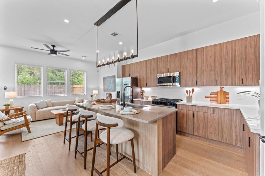 Striking and modern kitchen island serves as the centerpiece of this open-concept culinary space, featuring a waterfall quartz countertop that flows seamlessly down one side for a sculptural, high-end look. The island is framed by minimalist cabinetry in matte finishes, paired with bold pendant lighting that adds a touch of sophistication. Integrated bar seating invites casual dining and conversation, while the clean lines and neutral palette enhance the island’s sleek aesthetic. Striking and modern kitchen island serves as the centerpiece of this open-concept culinary space, featuring a waterfall quartz countertop that flows seamlessly down one side for a sculptural, high-end look. The island is framed by minimalist cabinetry in matte finishes, paired with bold pendant lighting that adds a touch of sophistication. Integrated bar seating invites casual dining and conversation, while the clean lines and neutral palette enhance the island’s sleek aesthetic.
