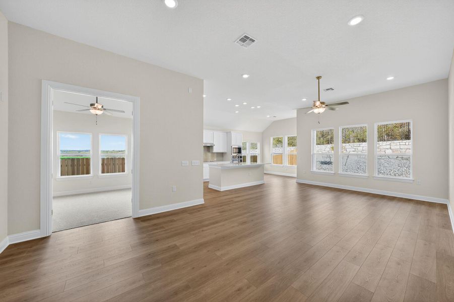 Unfurnished living room with a ceiling fan, healthy amount of natural light, recessed lighting, and dark wood-style floors Unfurnished living room with a ceiling fan, healthy amount of natural light, recessed lighting, and dark wood-style floors