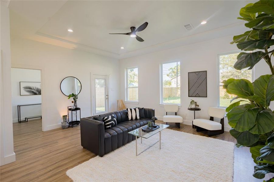 Living area featuring recessed lighting, wood finished floors, and a ceiling fan Living area featuring recessed lighting, wood finished floors, and a ceiling fan