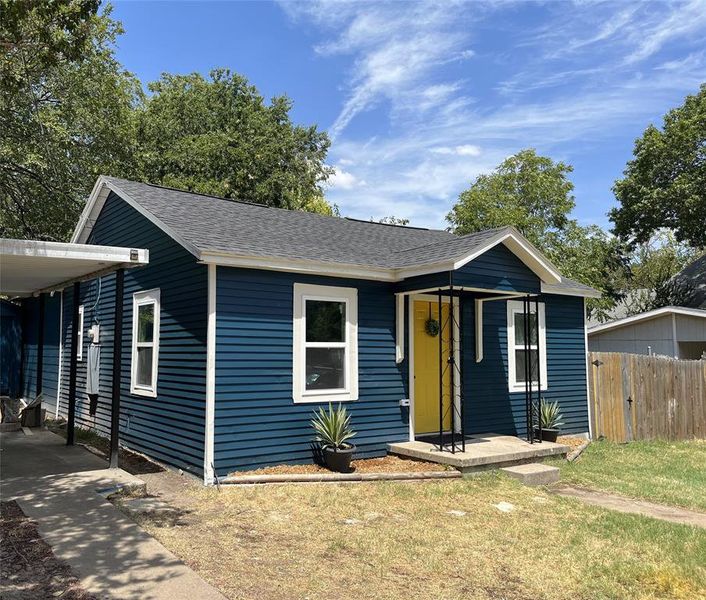 Single-story residence featuring blue horizontal siding with white trim, a dark gray shingle roof, and a prominent yellow front door