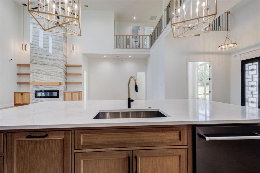 Expansive kitchen island featuring a deep undermount sink and a gold-finish gooseneck faucet