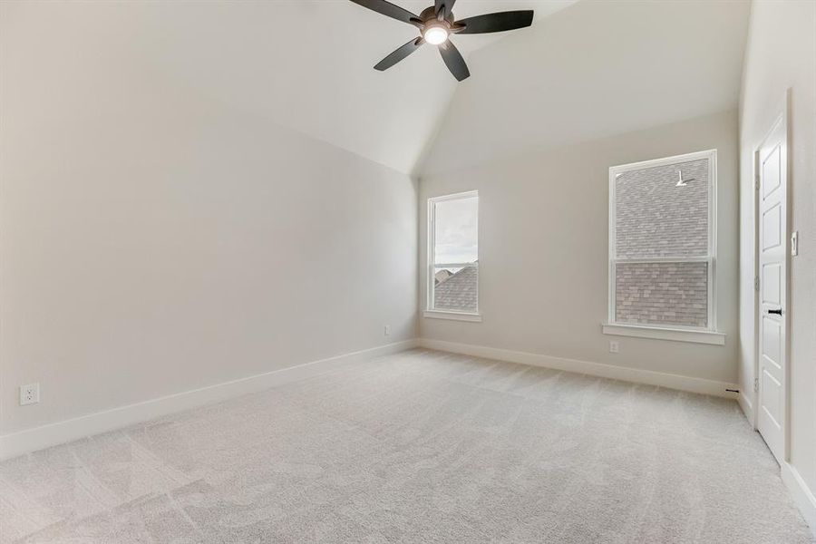 Unfurnished bedroom with light carpet, ceiling fan, and high vaulted ceiling Unfurnished bedroom with light carpet, ceiling fan, and high vaulted ceiling