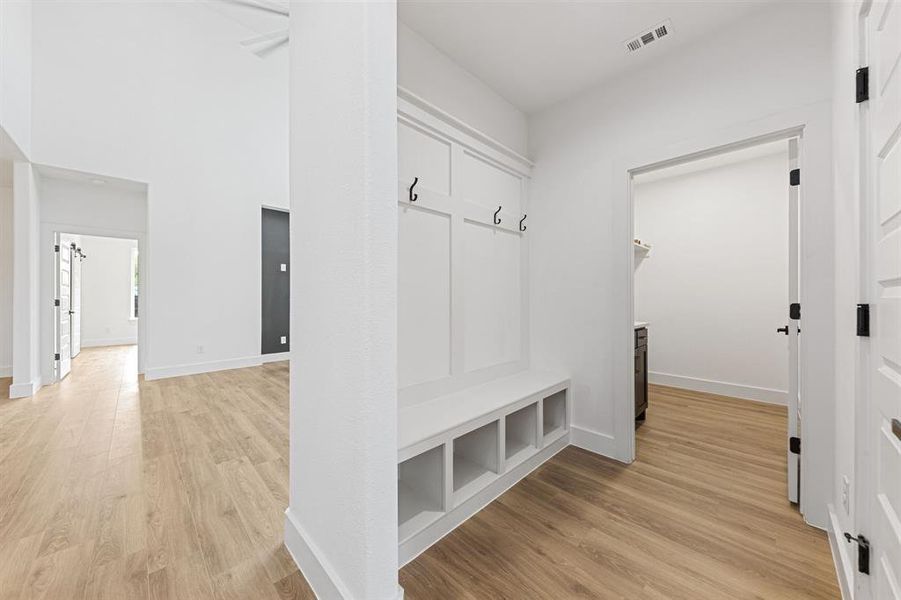 Entryway featuring light-toned flooring, a built-in bench with storage cubbies, and coat hooks Entryway featuring light-toned flooring, a built-in bench with storage cubbies, and coat hooks