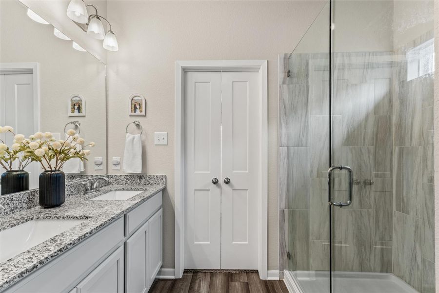 Indulge in this naturally illuminated bathroom, featuring a double vanity with stone counters and a spacious glass-enclosed shower. Indulge in this naturally illuminated bathroom, featuring a double vanity with stone counters and a spacious glass-enclosed shower.