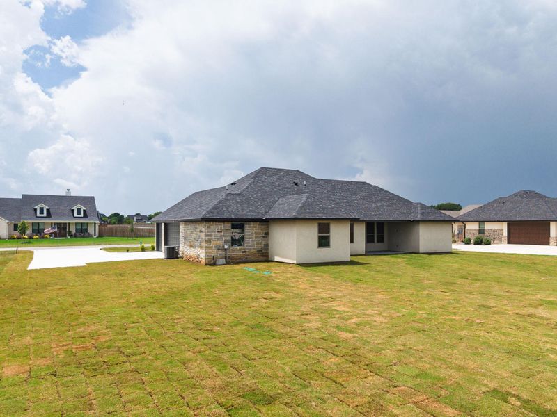 A newly sodded lawn frames this inviting contemporary residence with a sleek grey roof. A newly sodded lawn frames this inviting contemporary residence with a sleek grey roof.