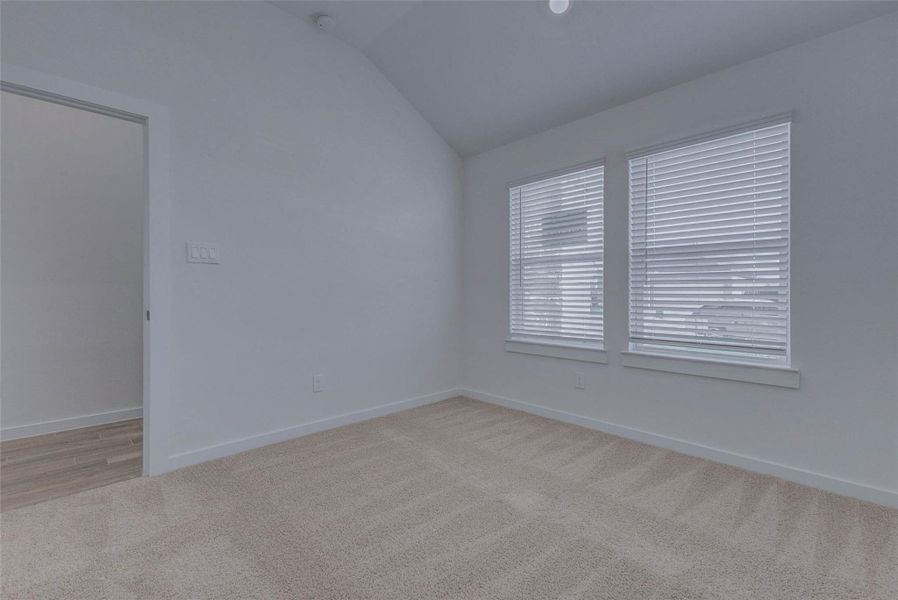 One of four spacious bedrooms, this versatile space features plush carpet, high ceilings, and oversized windows that flood the room with natural light. Ideal as a guest room, home office, or nursery, this retreat offers quiet comfort and flexibility all wrapped in a neutral palette ready for your personal touch.