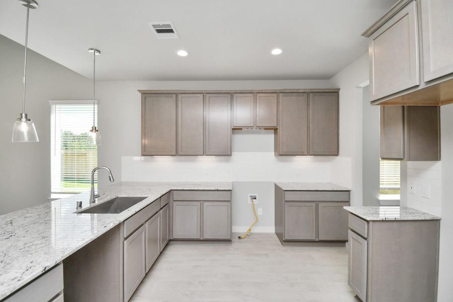 This kitchen is by far any chef’s dream! This spacious kitchen features high ceilings, light stained wood cabinets, granite countertop, SS appliances, modern tile backsplash, recessed lighting, extended counter space, space for breakfast bar, and a walk-in pantry all overlooking your huge family room. Sample photo of completed home with similar floor plan. Actual colors and selections may vary.