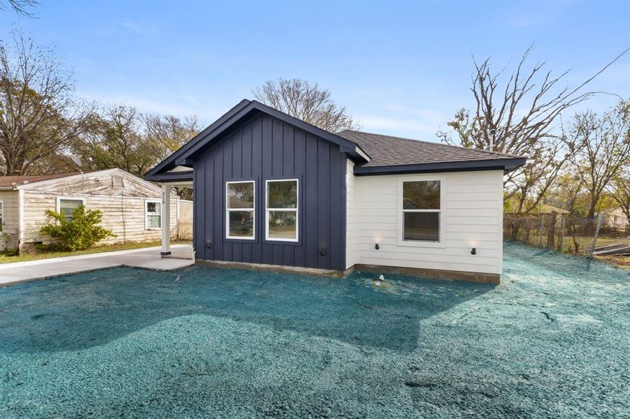 Back of property with board and batten siding and a shingled roof Back of property with board and batten siding and a shingled roof