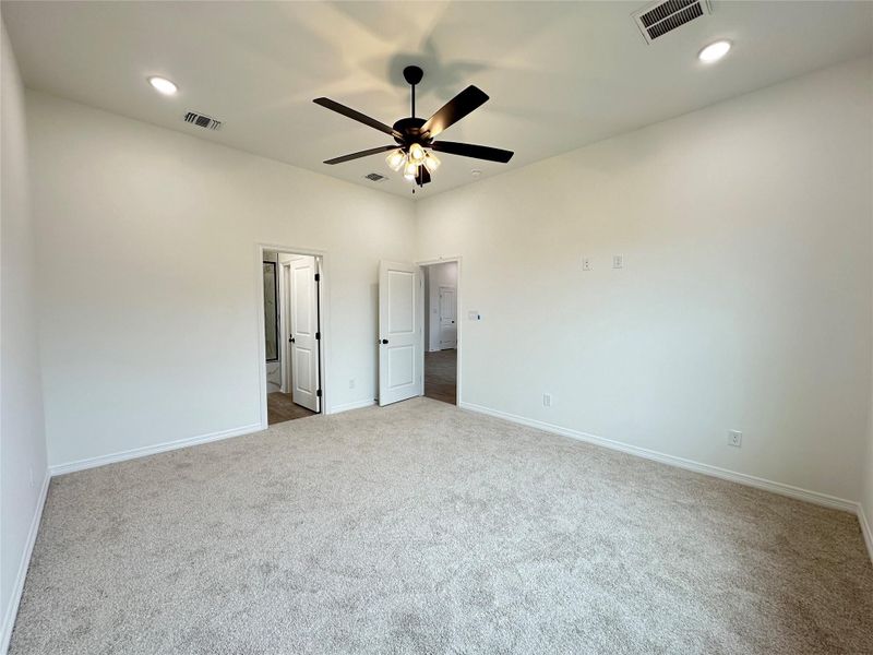 Carpeted interior room featuring white walls and a vaulted ceiling