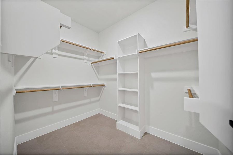 Walk in closet with light tile patterned floors Walk in closet with light tile patterned floors