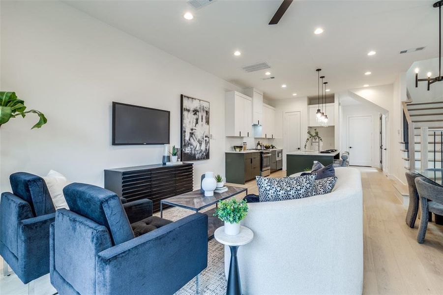 Living room featuring ceiling fan and light hardwood / wood-style flooring