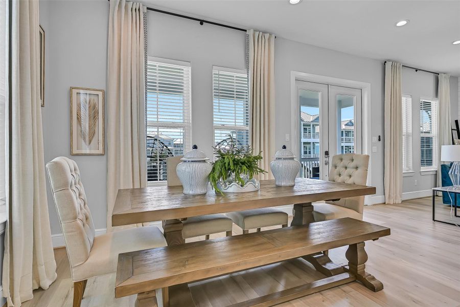 This dining area feels warm, connected, and ready for memorable gatherings. Large windows and high ceilings make the room feel even more open.