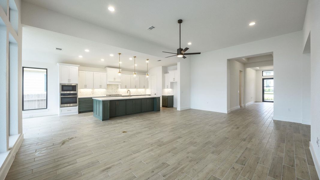 Kitchen with open floor plan, white cabinets, a ceiling fan, an island with sink, and recessed lighting Kitchen with open floor plan, white cabinets, a ceiling fan, an island with sink, and recessed lighting