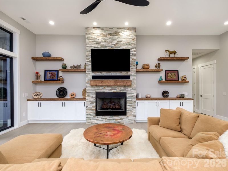 Custom stone fireplace flanked with floating open shelving
