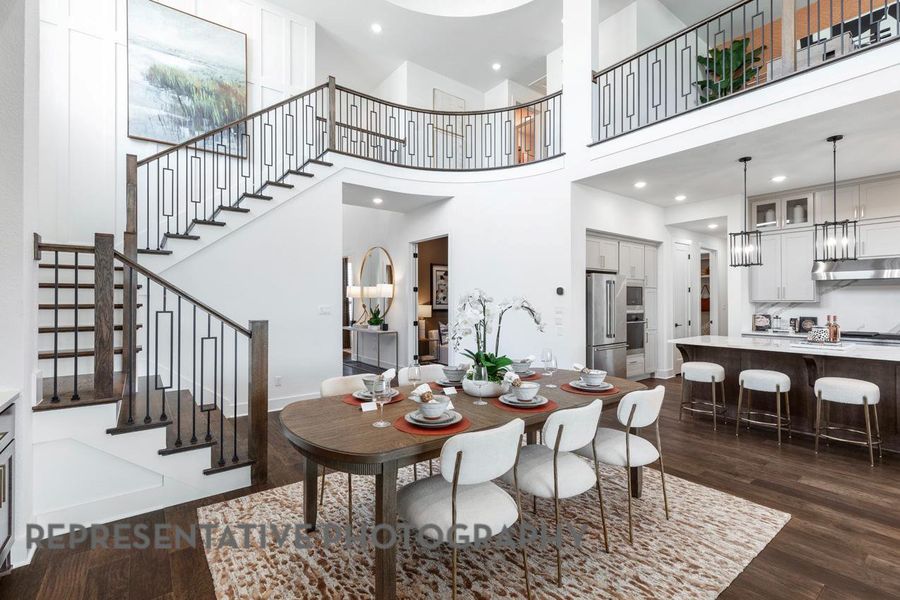 Dining room with dark wood-type flooring, stairway, a high ceiling, and recessed lighting