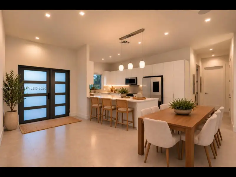 Open dining and kitchen area with stone countertops, recessed lighting, and a frosted-glass door that adds style and privacy