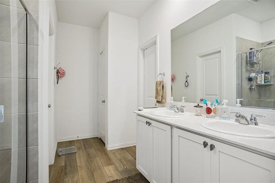 Bathroom featuring vanity, wood-type flooring, and an enclosed shower