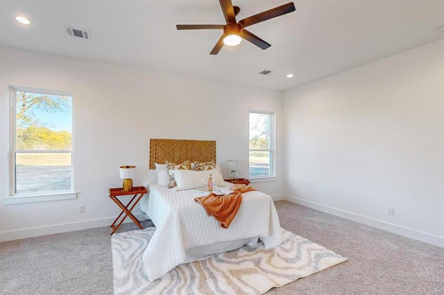 Carpeted bedroom featuring ceiling fan