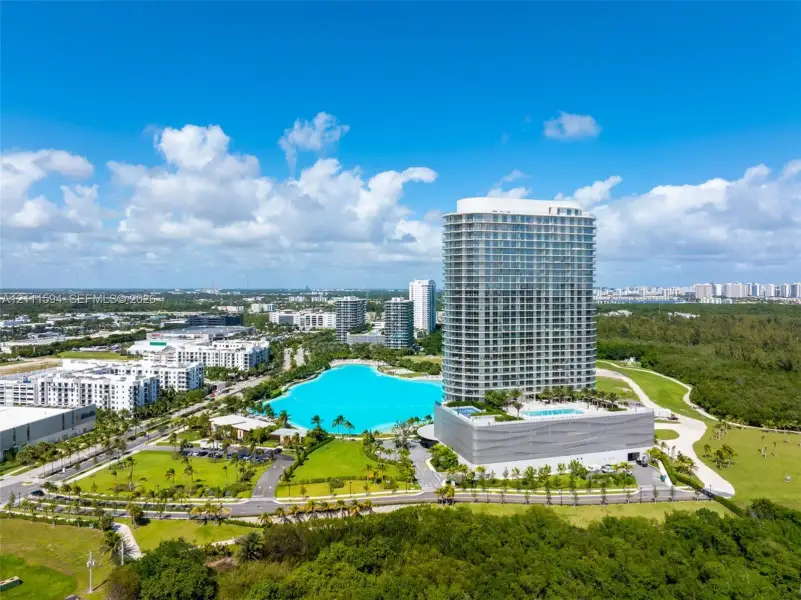 High-rise residential tower featuring a glass facade, private balconies, and a podium-level swimming pool High-rise residential tower featuring a glass facade, private balconies, and a podium-level swimming pool