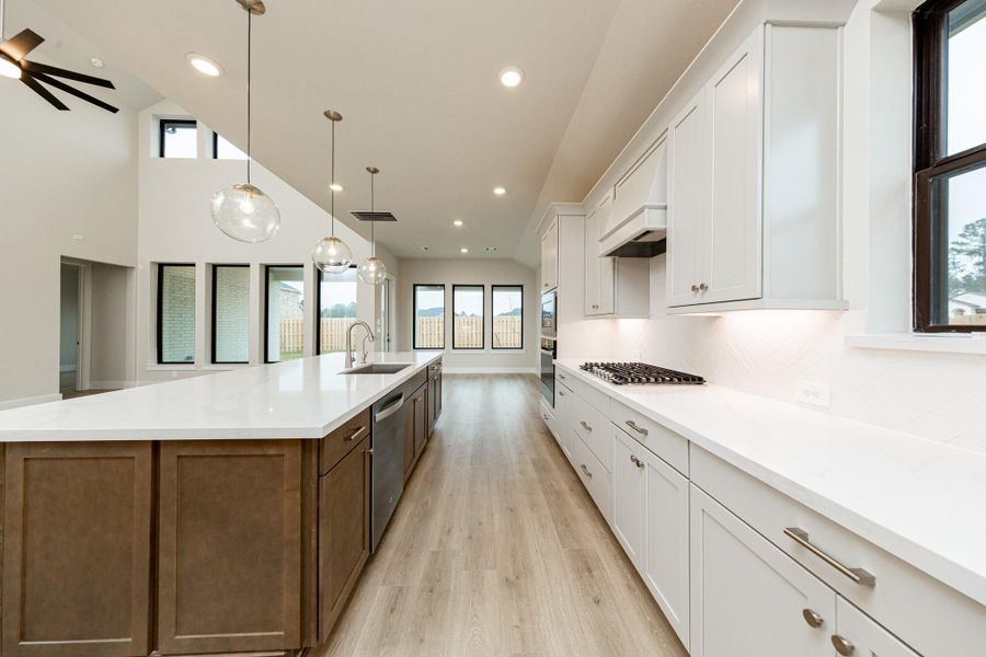 This gourmet, open-concept kitchen is truly the heart of the home, meticulously designed with both aesthetics and functionality in mind. White Shaker-style cabinetry, quartz countertops, modern backsplash and brushed nickel hardware giving it all a touch of luxury.