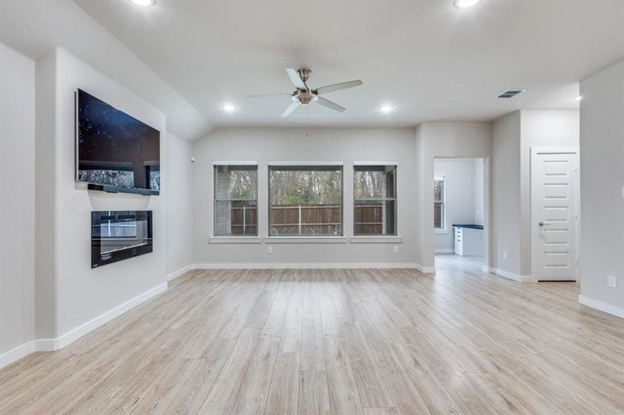 Unfurnished living room with light wood-type flooring, a ceiling fan, and recessed lighting Unfurnished living room with light wood-type flooring, a ceiling fan, and recessed lighting