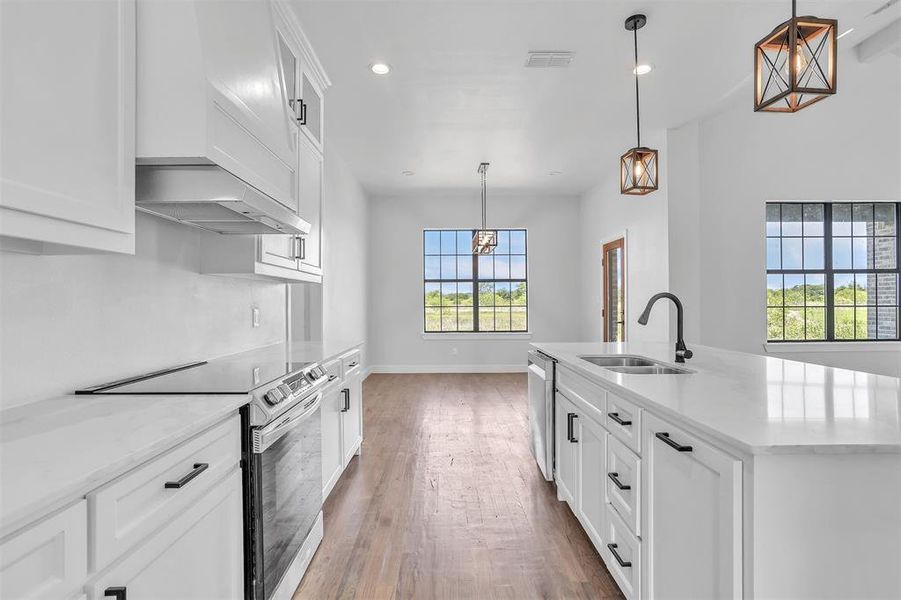 Kitchen with stainless steel appliances, wood-type flooring, and a wealth of natural light