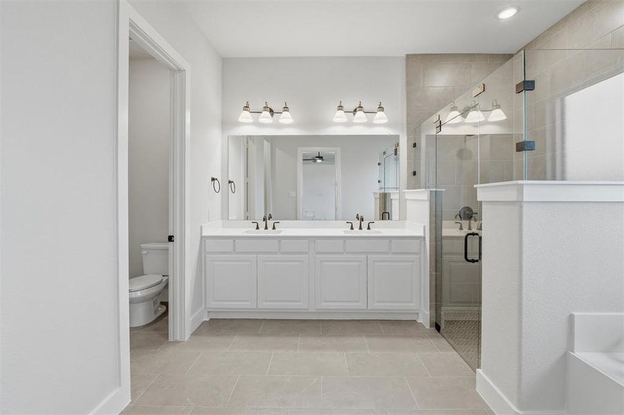 Bathroom featuring a dual vanity with white cabinetry, a large mirror, and recessed lighting