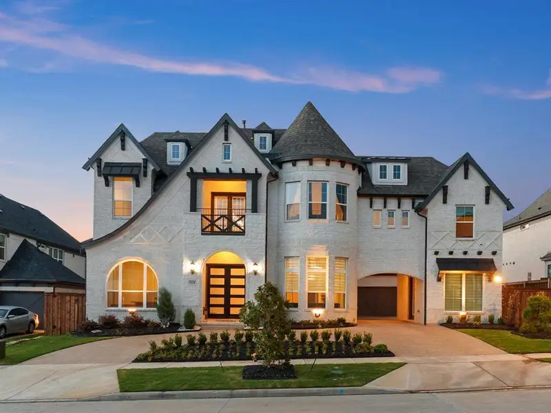 Stately residence featuring a prominent turret, light brick exterior, and dark trim accents Stately residence featuring a prominent turret, light brick exterior, and dark trim accents