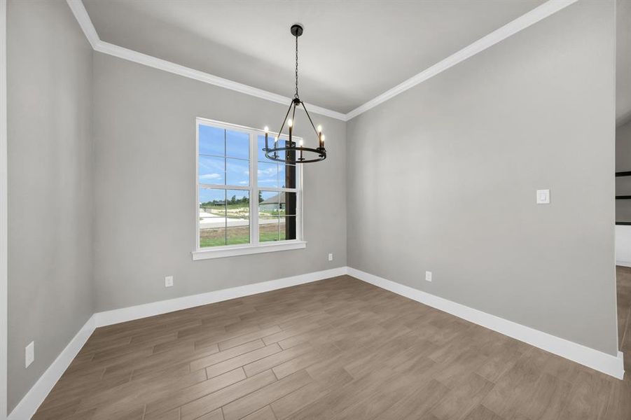 dining area featuring a notable chandelier, hardwood / wood-style floors, and ornamental molding