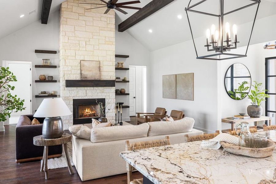 Virtually staged Living room with beamed ceiling, high vaulted ceiling, a fireplace, ceiling fan, and dark engineered wood finished floors Virtually staged Living room with beamed ceiling, high vaulted ceiling, a fireplace, ceiling fan, and dark engineered wood finished floors