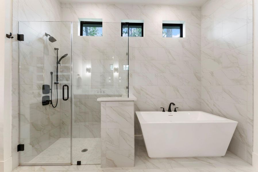 The oversized shower and freestanding tub create a luxurious focal point within the primary bath. Upgraded tile and clean architectural lines give the space a refined, serene feel.