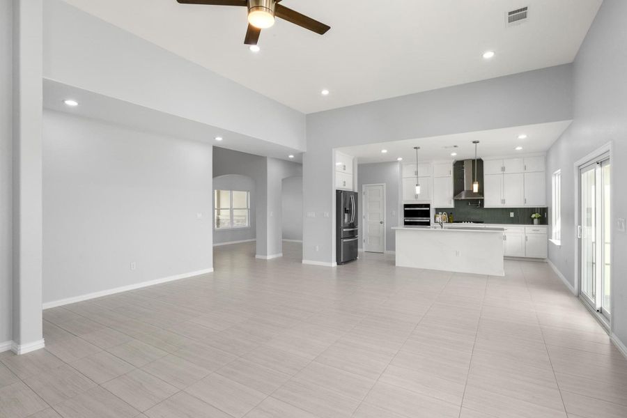 Unfurnished living room featuring a ceiling fan, recessed lighting, and arched walkways Unfurnished living room featuring a ceiling fan, recessed lighting, and arched walkways