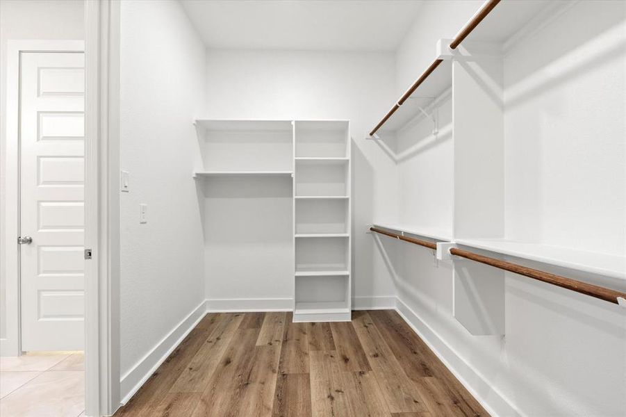 Spacious closet featuring light wood-type flooring Spacious closet featuring light wood-type flooring
