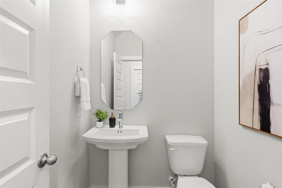 A stylish half bath near the main living areas provides comfort and convenience for guests while maintaining privacy throughout the home.