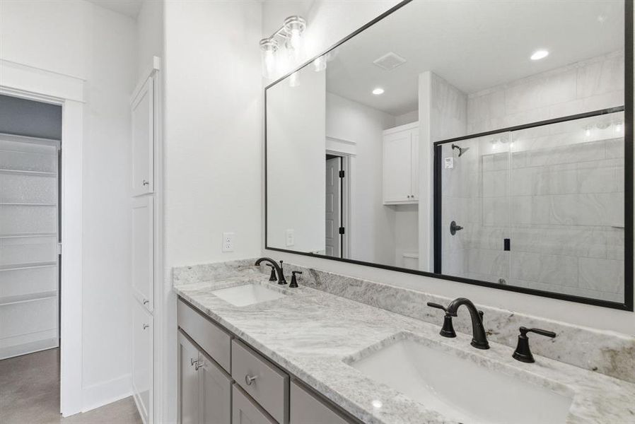 Full bath with double vanity, a stall shower, and recessed lighting