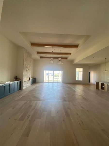 Unfurnished living room featuring hardwood / wood-style floors and beam ceiling