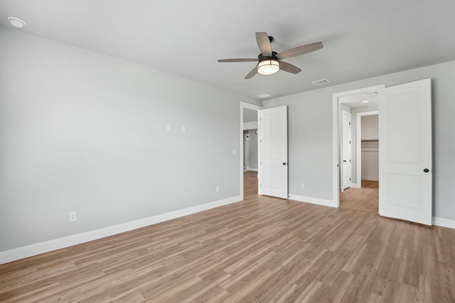 Unfurnished bedroom featuring light wood finished floors, visible vents, ceiling fan, and baseboards