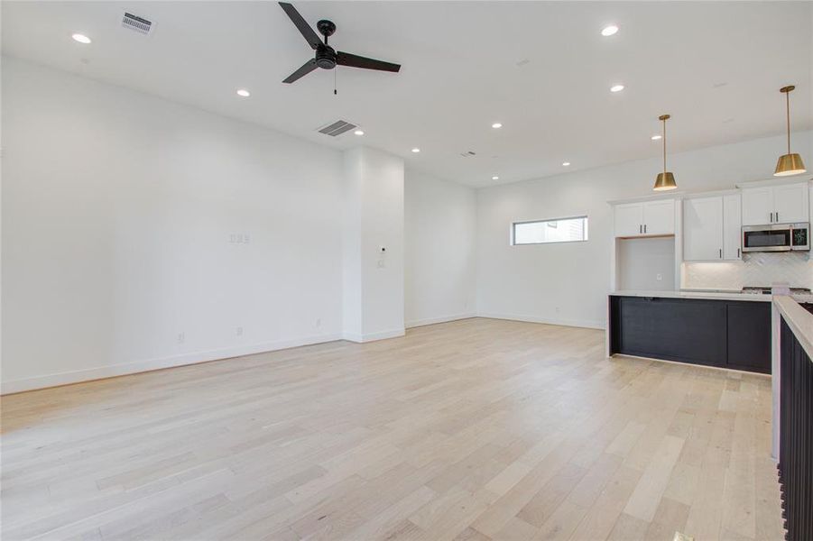 Main floor, wide open spaces, this shows living room looking into dining room with kitchen on right. Photos of similar completed home by same builder. Selections may differ.