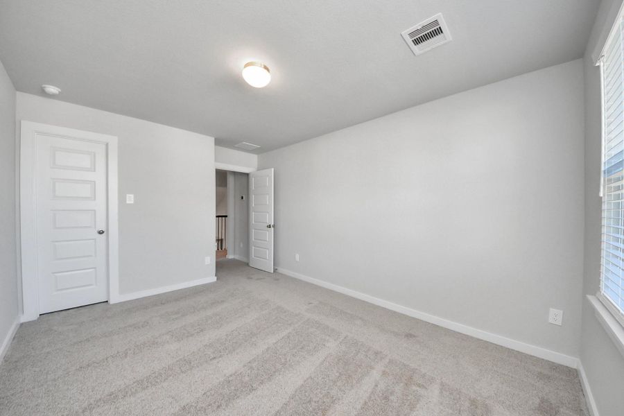 Generously sized secondary bedrooms featuring spacious closets, soft and inviting carpeting underfoot, large windows allowing plenty of natural light, and the added touch of privacy blinds for your personal retreat. Sample photo of completed home with similar floor plan. Actual colors and selections may vary.