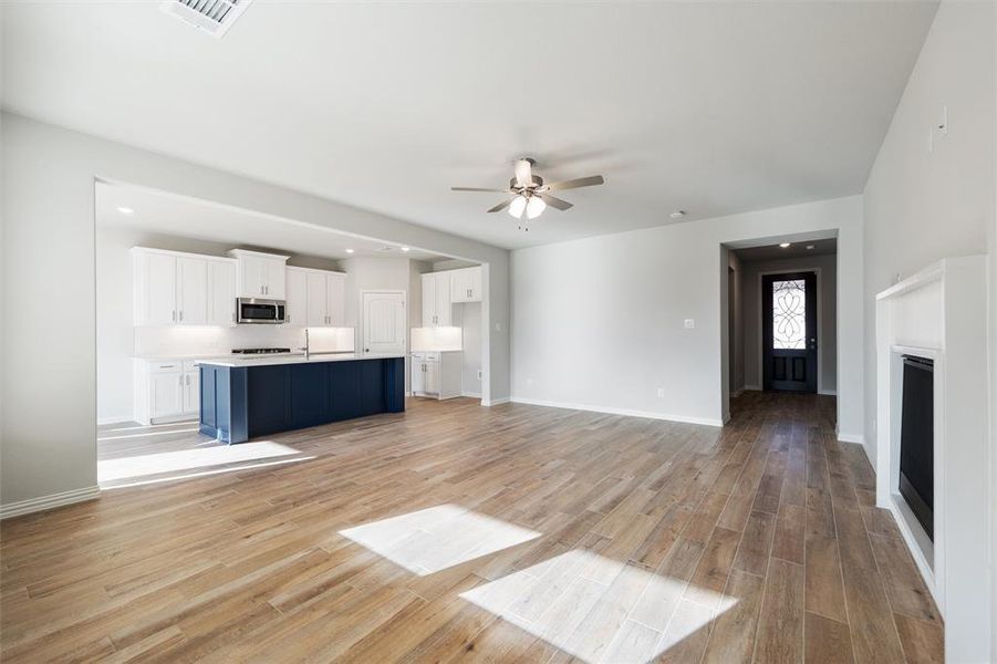 Unfurnished living room featuring light wood-style flooring, a ceiling fan, recessed lighting, and a fireplace