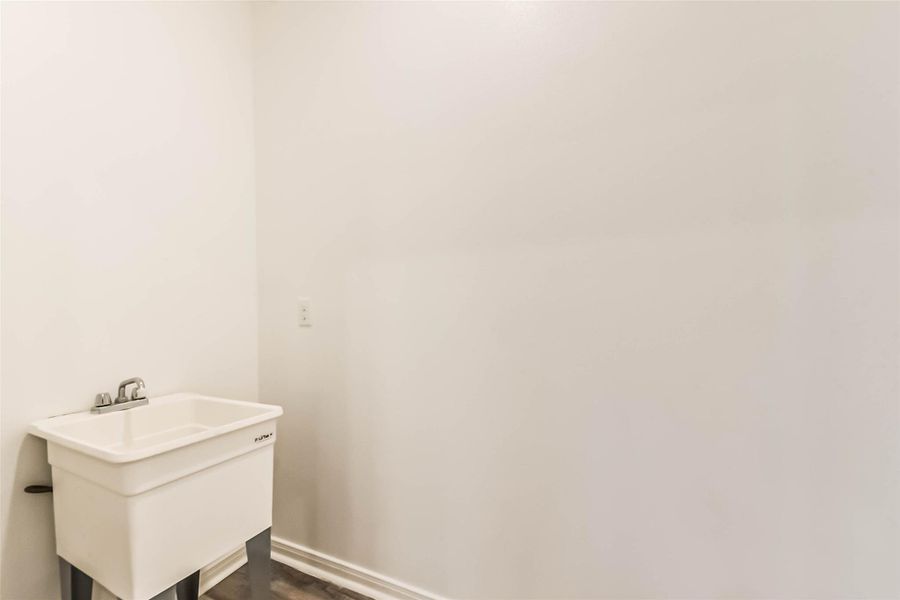 The house features a spacious utility room with ample room for both a washer and dryer. The house features a spacious utility room with ample room for both a washer and dryer.