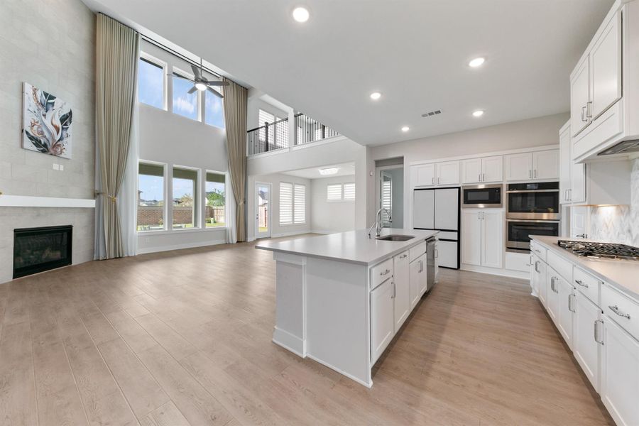 Stunning open-concept living space filled with natural light, featuring a spacious kitchen with a large island, sleek finishes, and ample cabinetry. Seamlessly connected to the living area, it’s perfect for both everyday living and entertaining.