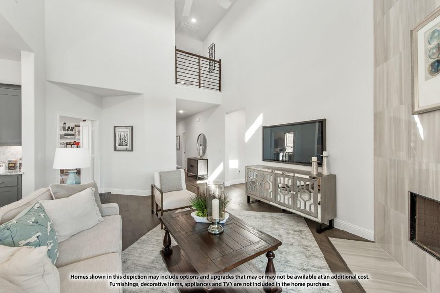 Living room with two-story ceiling, fireplace, and upper-level railing overlooking the space Living room with two-story ceiling, fireplace, and upper-level railing overlooking the space