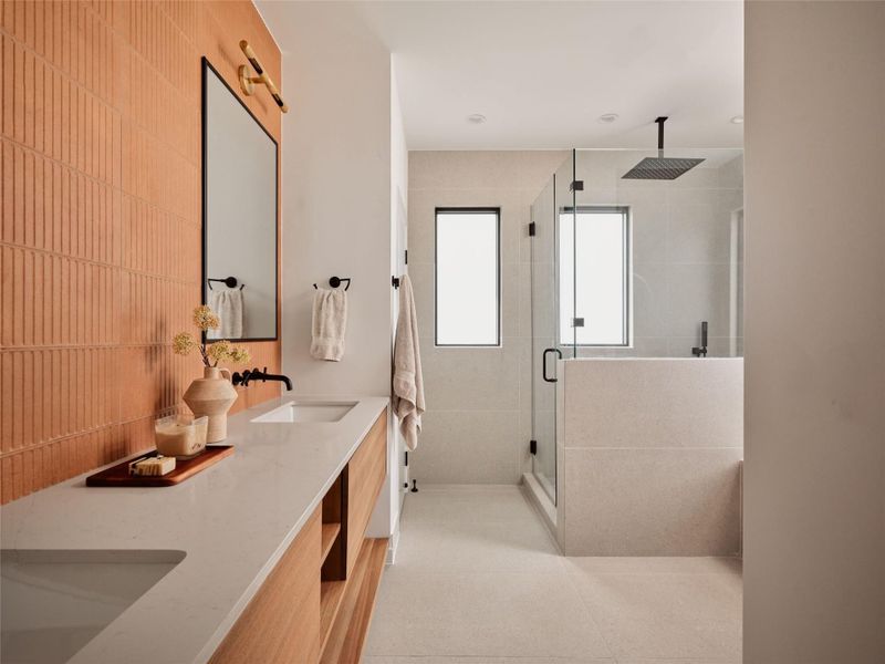 Full bathroom featuring double vanity and a stall shower