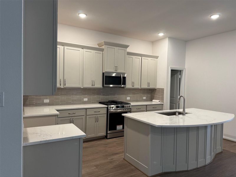 Modern kitchen design features gas range, sleek finishes, and open sightlines to the living room. Modern kitchen design features gas range, sleek finishes, and open sightlines to the living room.